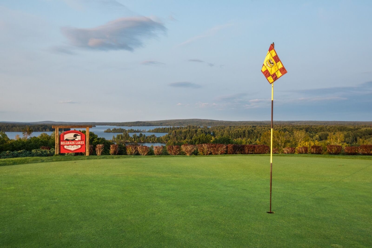 Golf course overlooking lakes with yellow flag